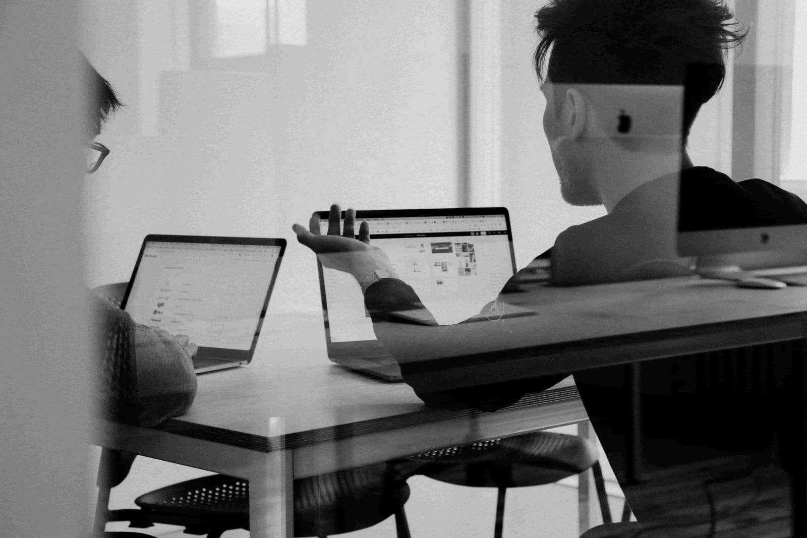 Knowledge workers collaborating at laptops in a modern office